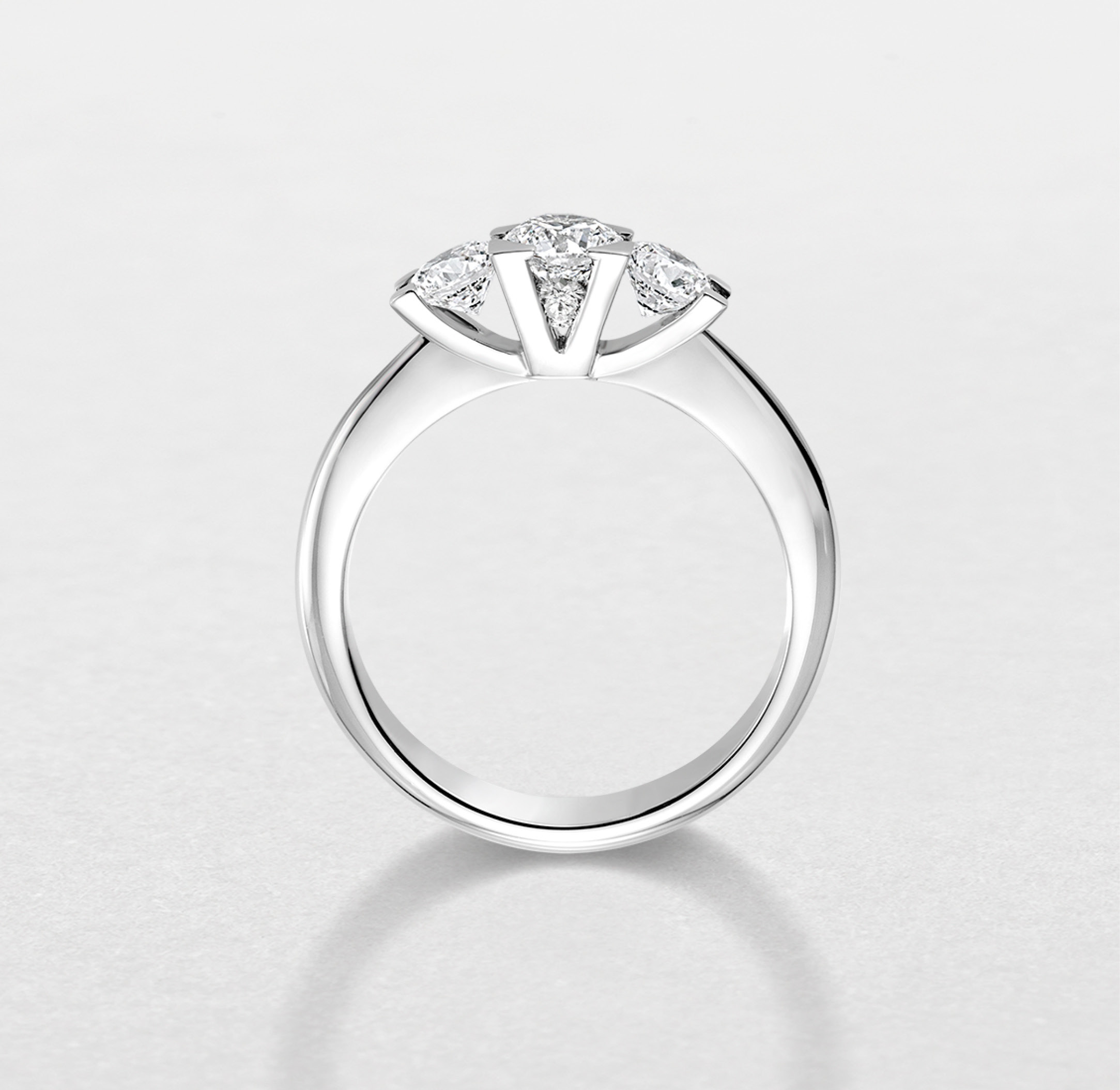 Still-life image of the trilogy ring in white gold with diamonds in the center. Profile with "V" by Visconti, Italian jeweler